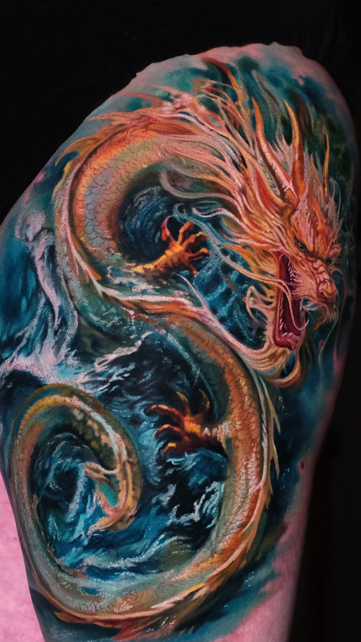 Körperwindungen und Schwanz des Drachen in schäumendem Wasser, Kopf am oberen Bildrand. Tattoo auf dem Oberschenkel, Wrocław.