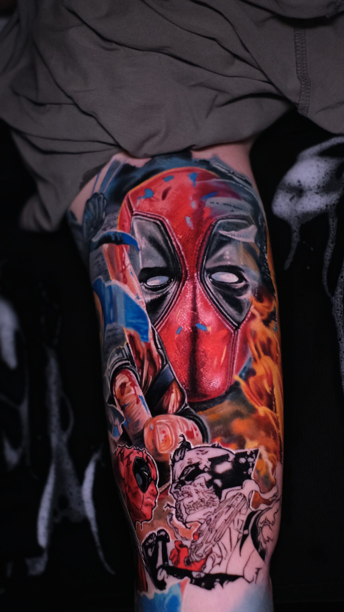 Maske und unterer Teil des Sleeves mit dem Comic-Deadpool und der Katana – Tattoo auf dem Arm, Wrocław.