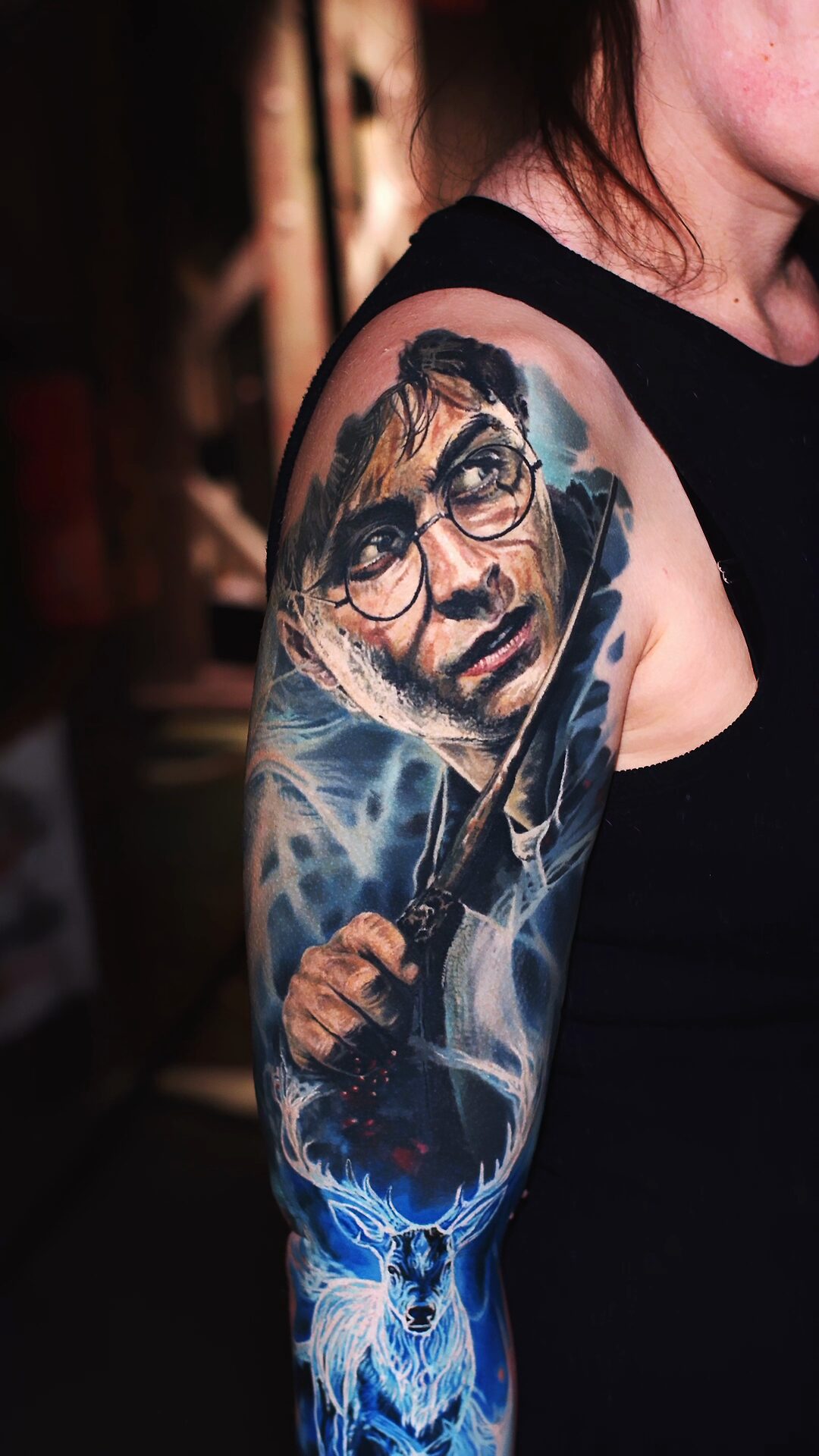 Portret Harry'ego Pottera w okrągłych okularach i z różdżką – realistyczny tatuaż w kolorze, Wrocław