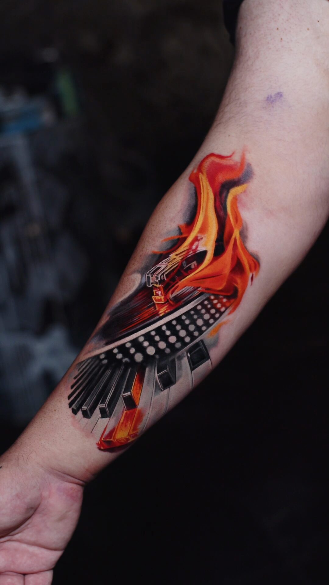 Tatuaż na przedramieniu – ogień, muzyka, fortepian i gramofon – Alex666cold.