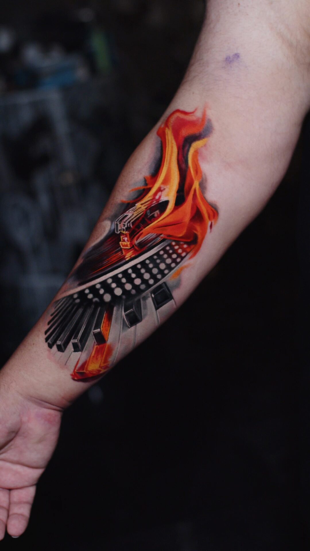 Brennendes Klavier und Technics-Plattenspieler – Tattoo am Unterarm