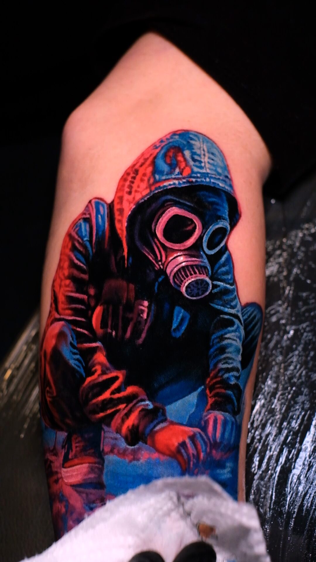 Figur mit Gasmaske auf dem Oberarm – Seitenansicht, rotes und blaues Licht.
